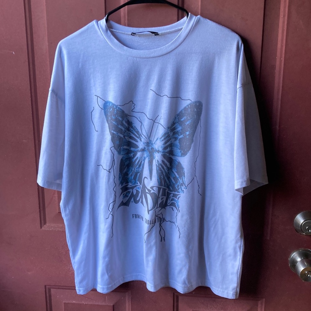 white tee shirt with a blue butterfly and black light strikes